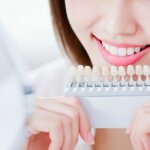 ホワイトニングをして歯の色をチェックする女性