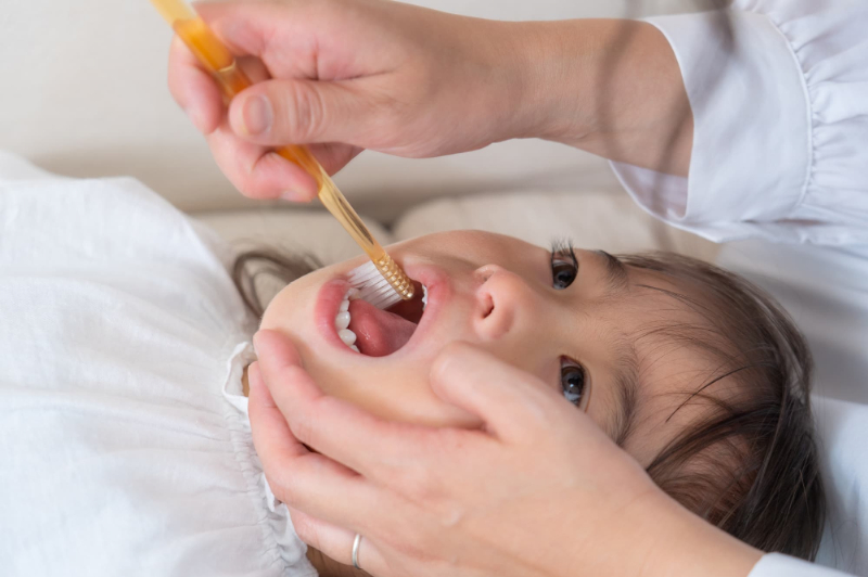 歯医者でフッ素塗布をする子ども