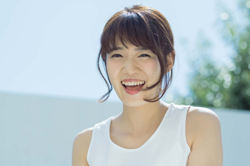 ホワイトニングをした白い歯で笑う女性