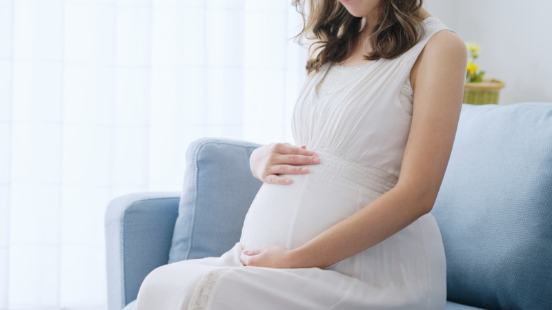 妊娠中のお腹に手をそえる女性