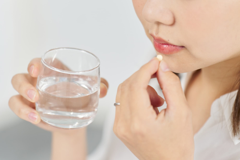 鎮痛剤を服用する女性